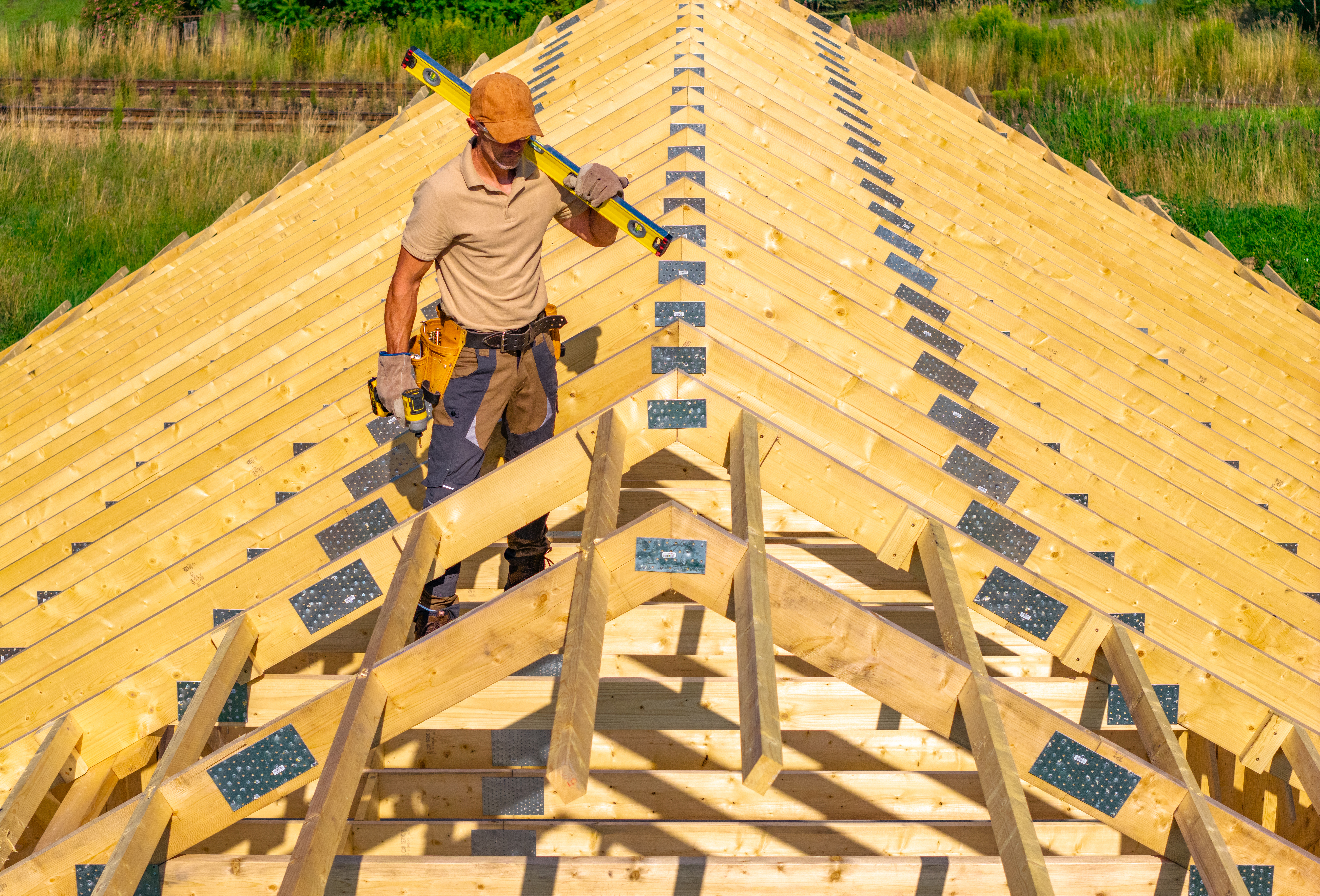Construction worker inspecting roof framework for quality
